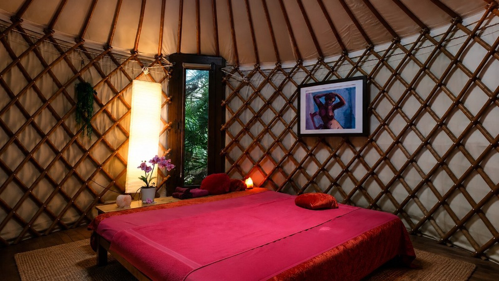 Ocean Tantra Massage Denia yurt studio — pink treatment bed, warm lighting and wooden lattice